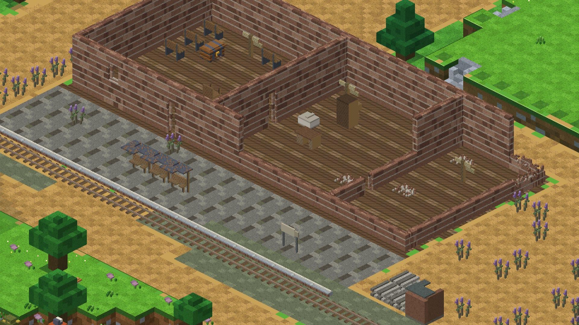 The disused railway station in isometric view: rails, a paved platform and the roofless brick station building